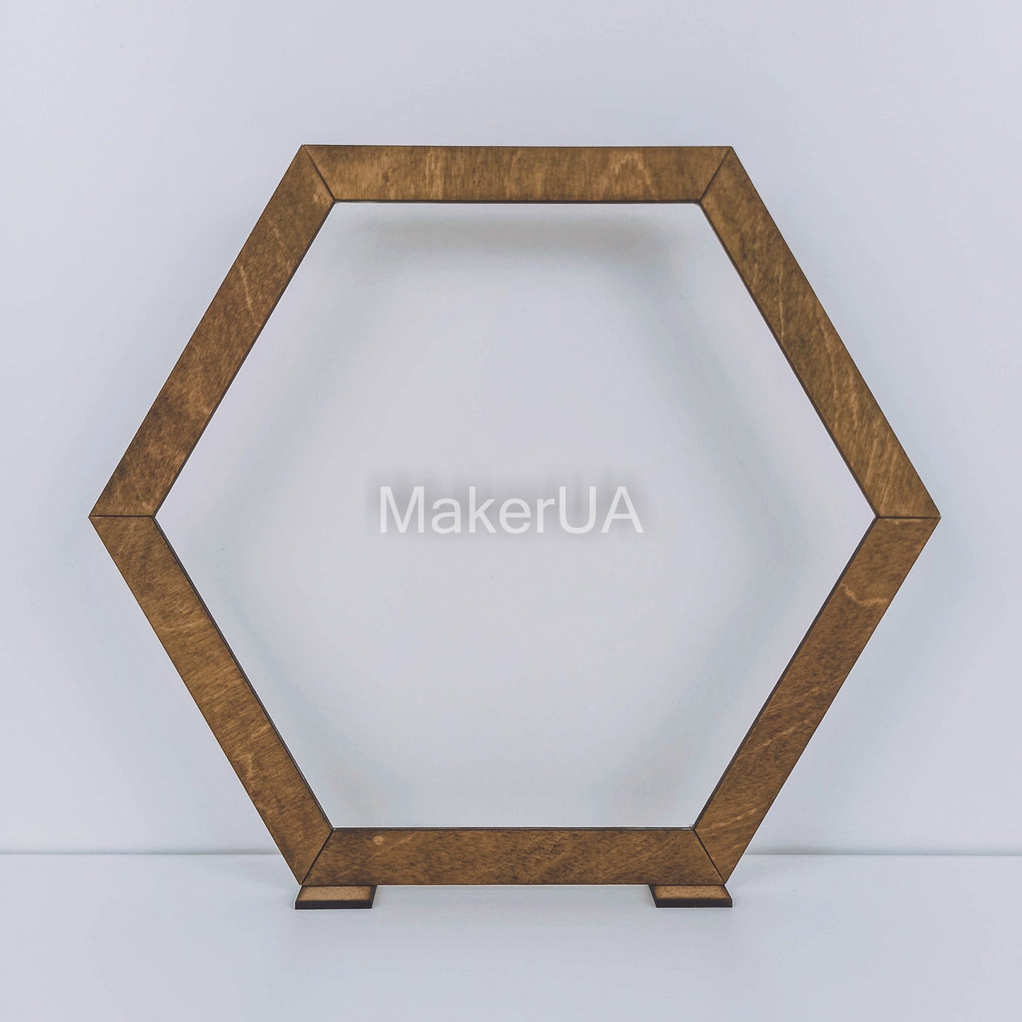 Large open hexagonal wooden arch with a natural brown wood finish. Rustic boho backdrop frame for outdoor wedding ceremonies and floral displays.