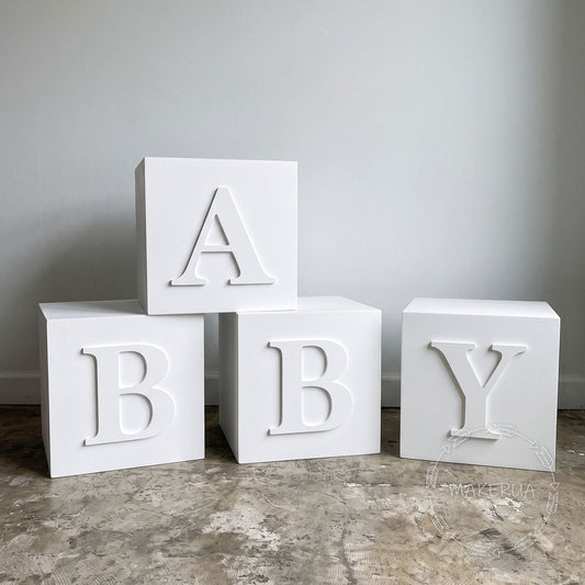 giant white blocks with BABY letters on a gray surface.