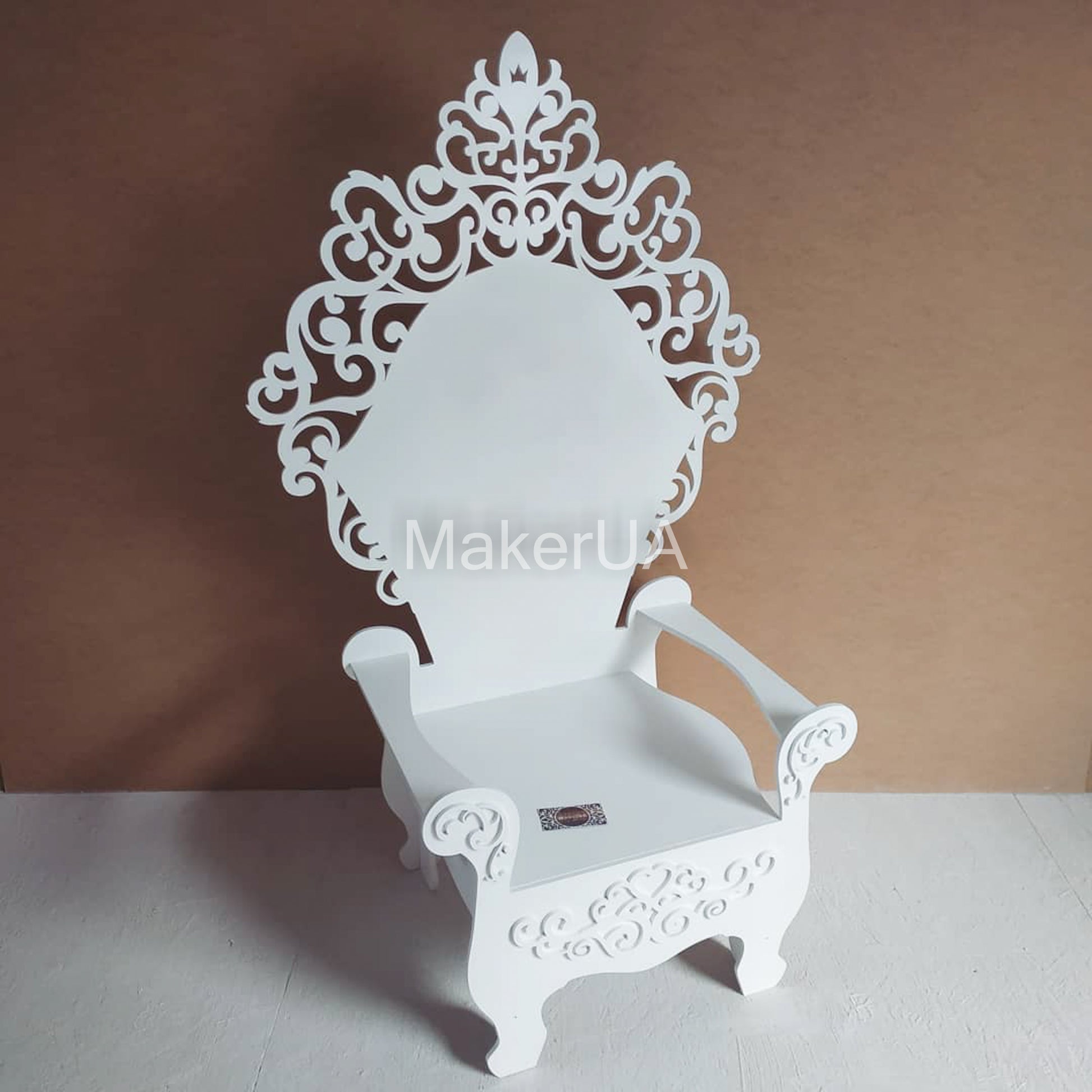White ornate wooden throne chair with elegant filigree design, decorated for a Christmas party photo zone. Classic royal seating for holiday events and birthday props.