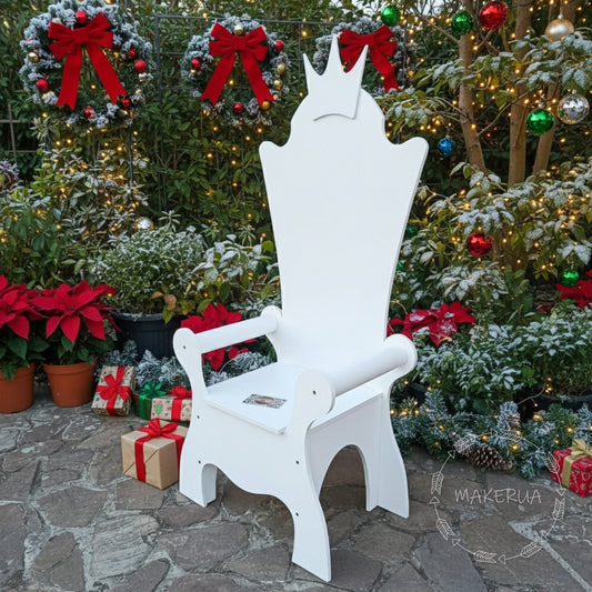 White wooden princess chair with a classic crown-shaped backrest, set outdoors in a snowy winter garden with gifts. Outdoor seating photo prop for kids birthday parties and Christmas events.