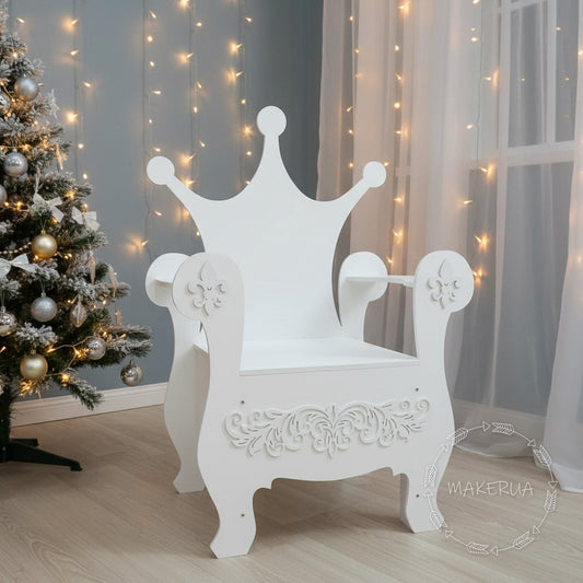 White wooden event chair with a solid crown-shaped backrest and decorative swirl carvings on the front panel. Set indoors with sheer curtains and fairy lights. Premium seating prop for baby showers and royal themed birthdays.